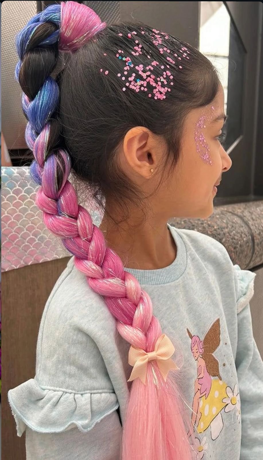 A high braided ponytail featuring a soft ombre transition from deep lavender to pastel pink extensions.
